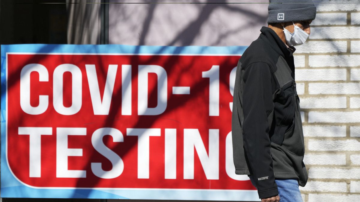 Le panneau d'essai de Covid est affiché dans un magasin alors qu'un piéton passe devant à Chicago, le lundi 11 mars 2024. 