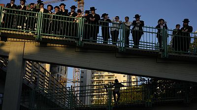 Ultra-Orthodox Jews gather on a bridge as others block a road to protest against military recruitment, in Bnei Brak, near Tel Aviv, Israel, Thursday, Aug. 1, 2024. 