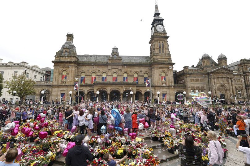 Des habitants devant l'hôtel de ville le 5 août lors d'une veillée à la mémoire des victimes de l'attaque au couteau. 