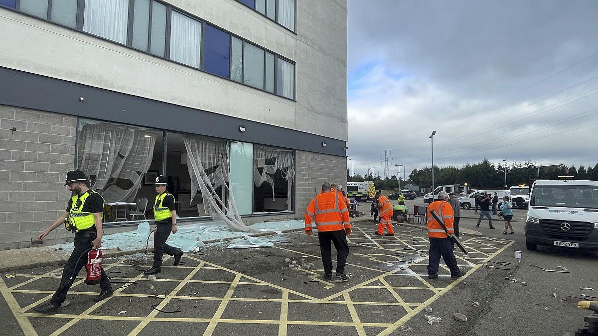 Limpieza de escombros en el Holiday Inn Express en Rotherham, Inglaterra, el lunes 5 de agosto de 2024, atacado por extremistas antiinmigración el domingo.