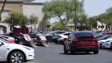 A Tesla vehicle joins a parking lot full of Tesla vehicles stored at a shopping mall (file photo)