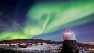 Aurora borealis ili polarna svjetlost vidljiva je na nebu iznad svjetionika u selu Strand u blizini Tromsoa u sjevernoj Norveškoj. 