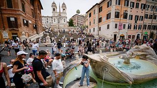 Des personnes font la queue pour s'approvisionner en eau fraîche à la fontaine historique de Barcaccia, alors que les températures atteignent 37 degrés Celsius, dans le centre de Rome.