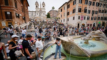 People line up to take fresh water from the historical Barcaccia fountain as temperatures reached 37 degrees Celsius, in downtown Rome.