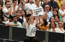 A woman holds up a placard reading "Bullfighting is a sin" during Pope Francis weekly general audience in the Paul VI hall at the Vatican, Wednesday, Aug. 7, 2024. 