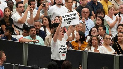 A woman holds up a placard reading "Bullfighting is a sin" during Pope Francis weekly general audience in the Paul VI hall at the Vatican, Wednesday, Aug. 7, 2024. 