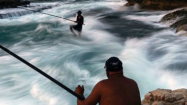 Fishermen cast their fishing lines into the Mediterranean Sea from a rocky area along the Beirut coastline, on a sweltering hot day in Beirut, Lebanon, 27 July, 2024.