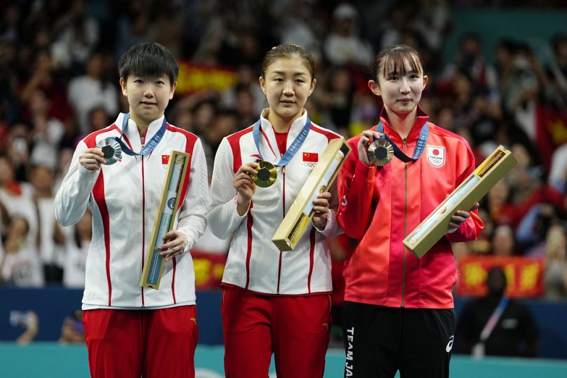 Gold medalist China's Chen Meng, center, silver medalist China's Sun Yingsha, left, and bronze medalist Japan's Hina Hayata pose after the women's singles table tennis final