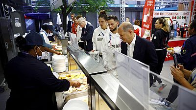 Bundeskanzler Olaf Scholz probiert das Essen in der olympischen Kantine