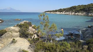 Il Monte Athos, la montagna sacra e la penisola che ospita i monasteri cristiani ortodossi, si vede di fronte al mare dalla spiaggia di Kavourotrypes il 24 luglio 2020 a Halkidiki, in Grecia.