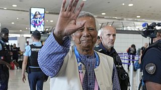 Nobel laureate Muhammad Yunus waves goodbye to the media at Charles de Gaulle's airport in Roissy, north of Paris, Wednesday, Aug. 7, 2024. (AP Photo/Michel Euler)