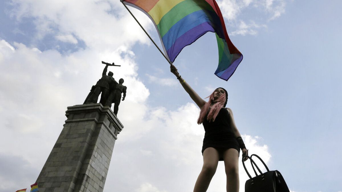 An activist waves a rainbow flag in front of the Monument of the Soviet Army, during the Sofia Gay Pride Parade in Sofia, Saturday, June 27, 2015.