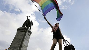 Un activista ondea una bandera arcoíris frente al Monumento del Ejército Soviético, durante el Desfile del Orgullo Gay de Sofía, en Sofía, el sábado 27 de junio de 2015.