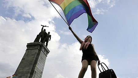 Un activista ondea una bandera arcoíris frente al Monumento del Ejército Soviético, durante el Desfile del Orgullo Gay de Sofía, en Sofía, el sábado 27 de junio de 2015.