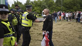 Police officers face protesters outside the Holiday Inn Express in Rotherham, England, Sunday, Aug. 4, 2024.