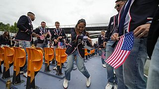 Logan Edra, da equipa de breakdance dos Estados Unidos, dança com os seus colegas de equipa no rio Sena, em Paris, França, durante a cerimónia de abertura.