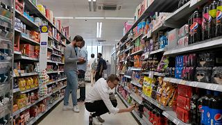 Shoppers buy food in a supermarket in London, on Aug. 17, 2022.