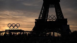 Spectators watch a quarterfinal beach volleyball match between Australia and Switzerland at sunset at Eiffel Tower Stadium at the 2024 Summer Olympics, Tuesday, Aug. 6, 2024