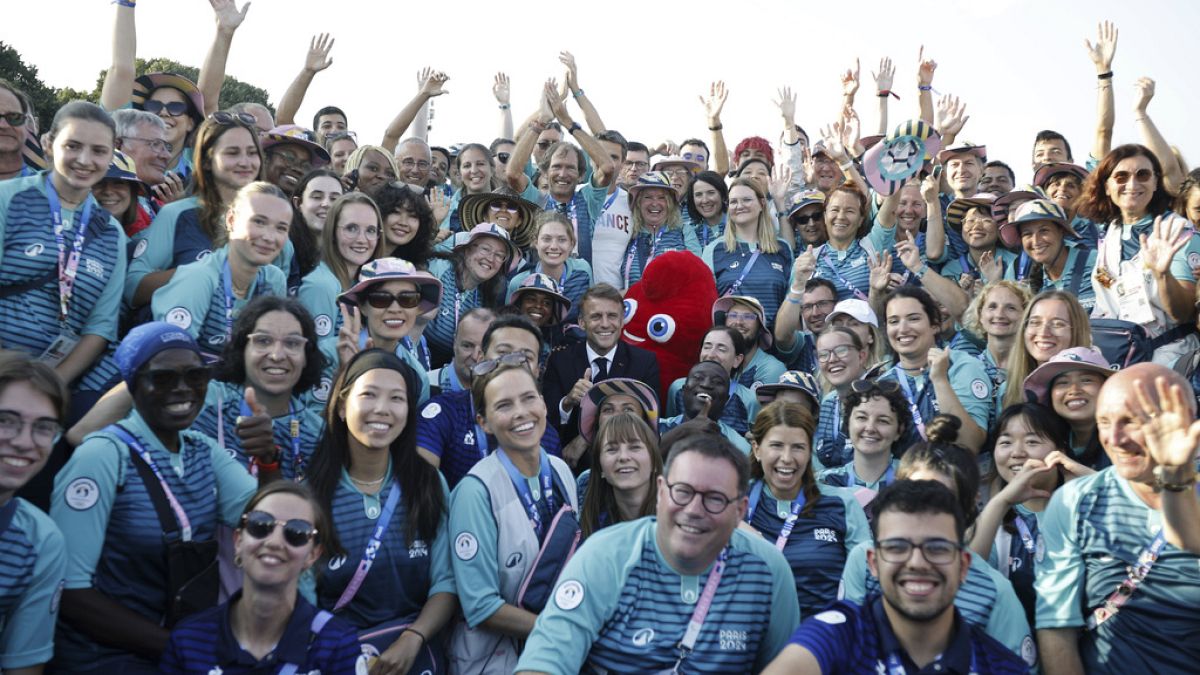 French President Emmanuel Macron poses with volunteers