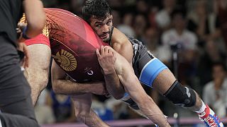 Greece's Dauren Kurugliev and Iran's Hassan Yazdanicharati compete during their men's freestyle 86kg quarterfinal wrestling match, at Champ-de-Mars Arena