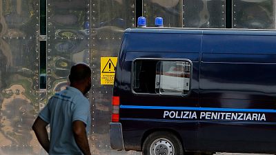 An Italian penitentiary police van drives by the front gate of the Rebibbia prison in Rome.