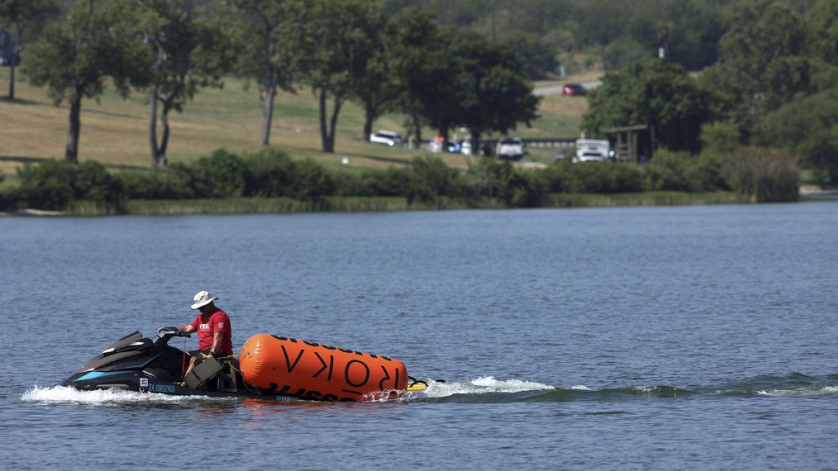 Bir jet ski, 8 Ağustos 2024 Perşembe günü Fort Worth, Teksas'ta koşu yüzme etkinliği sırasında bir sporcunun boğulduğu Marine Creek Gölü'ndeki CrossFit Oyunları'ndan şamandıraları çekiyor