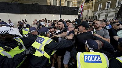 Agentes da polícia entram em confronto com manifestantes durante uma manifestação de protesto "Basta!" em Whitehall, Londres, quarta-feira, 31 de julho de 2024