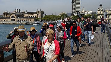 In this Wednesday, May 25, 2016 photo, tourists walk at the Maremagnum Port in Barcelona, Spain