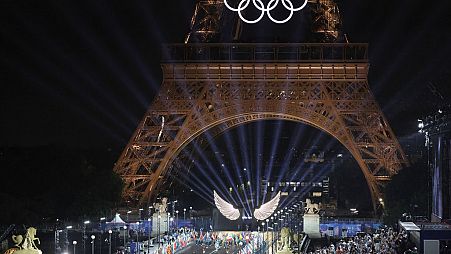 volunteers carrying flags of Olympic teams on the Iena Bridge in Paris, France, during the opening ceremony of the 2024 Summer Olympics, Friday, July 26, 2024.