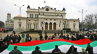 Protesters hold a large Bulgarian national flag and shout slogans during an anti government protest in front of the Bulgarian parliament building in the capital Sofia, 2009.