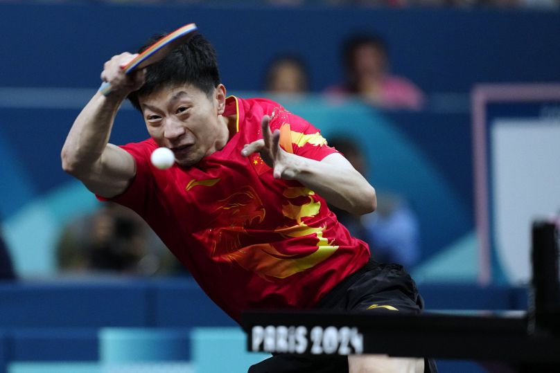 Ma Long, da China, com o seu colega de equipa Wang Chuqin, joga contra Anton Kallberg e Kristian Karlsson, da Suécia, durante o jogo de ténis de mesa por equipas da medalha de