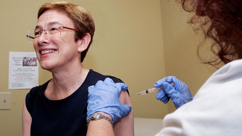 A woman receives a shot of the H1N1 flu vaccine from a research nurse.