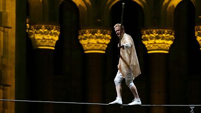 Philippe Petit walks a tightrope inside the Cathedral Church of St. John the Divine to mark the 50th anniversary of his World Trade Center Twin Towers high-wire walk