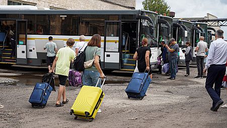 El viernes 9 de agosto de 2024, unos familiares llevan las maletas de sus hijos desde la región de Kursk ayudándoles a partir hacia la región rusa de Moscú. 