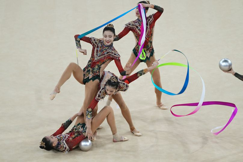 A equipa da China actua com fitas e bolas na final da ginástica rítmica geral, na Arena La Chapelle, durante os Jogos Olímpicos de verão de 2024