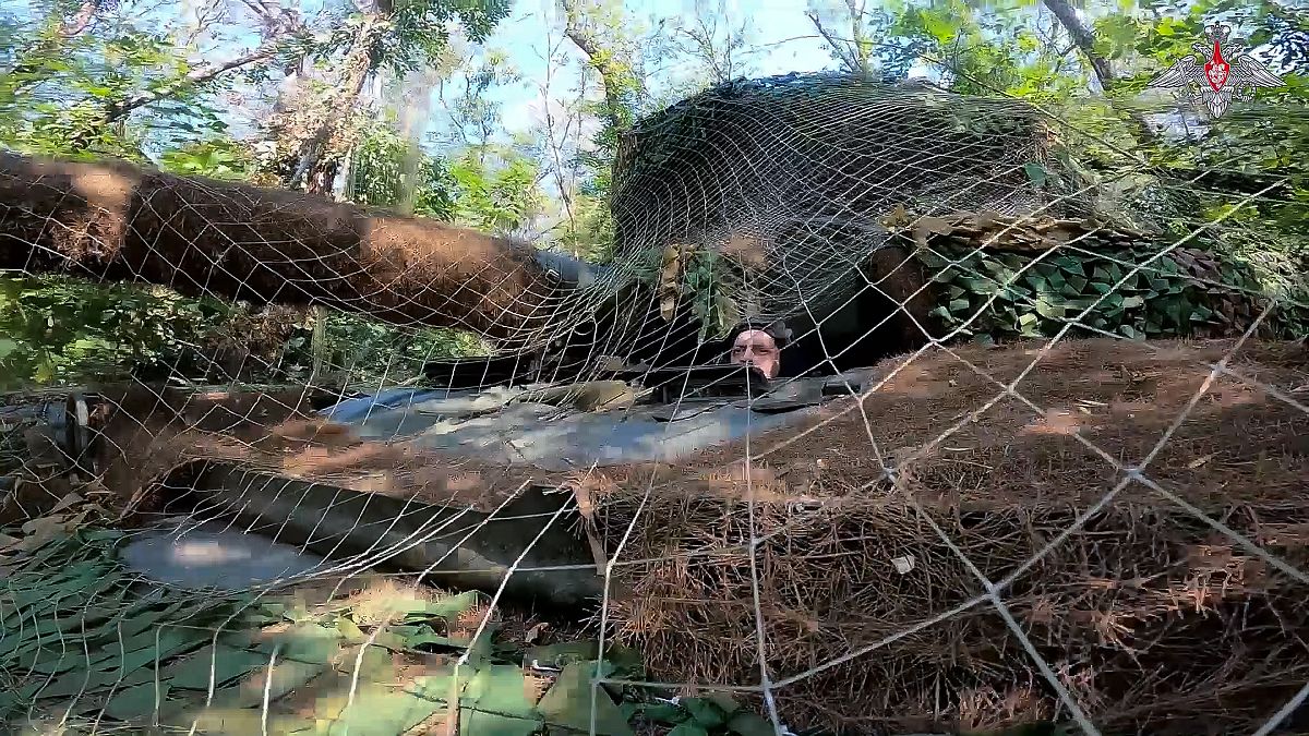 Un tanque del Ejército ruso cubierto con una red de camuflaje toma posición en un área de la región de Kursk, Rusia.