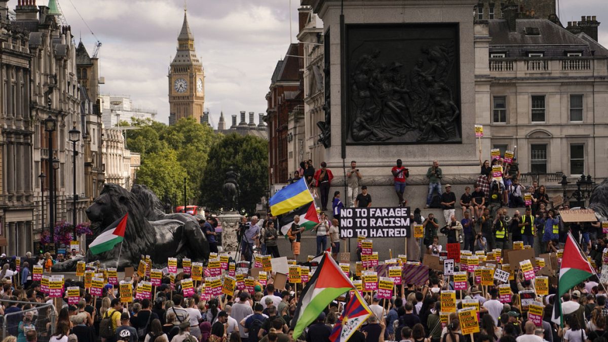 İnsanlar 10 Ağustos 2024 Cumartesi günü Londra'da aşırı sağ karşıtı bir protesto sırasında ellerinde pankartlarla yürüyor.