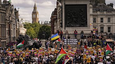 People hold placards as they march during an anti-far right protest in London, Saturday, Aug. 10, 2024.