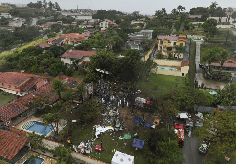 Firefighters and rescue teams work at the site in a residential area where an airplane with 62 people on board crashed in Vinhedo, Sao Paulo state, Brazil