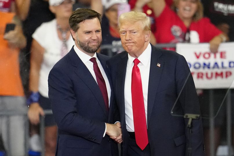 Republican vice presidential candidate JD Vance, left, and Republican presidential candidate former President Donald Trump, shake hands at a campaign rallying early August