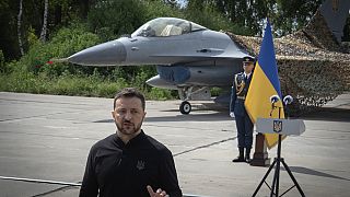 Volodomir Zelenszkij ukrán elnök egy Ukrajnának adományozott F-16os vadászgép előtt