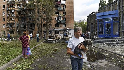 Residentes de um edifício de apartamentos danificado após um bombardeamento do lado ucraniano abandonam a área em Kursk, Rússia, domingo, 11 de agosto de 2024.