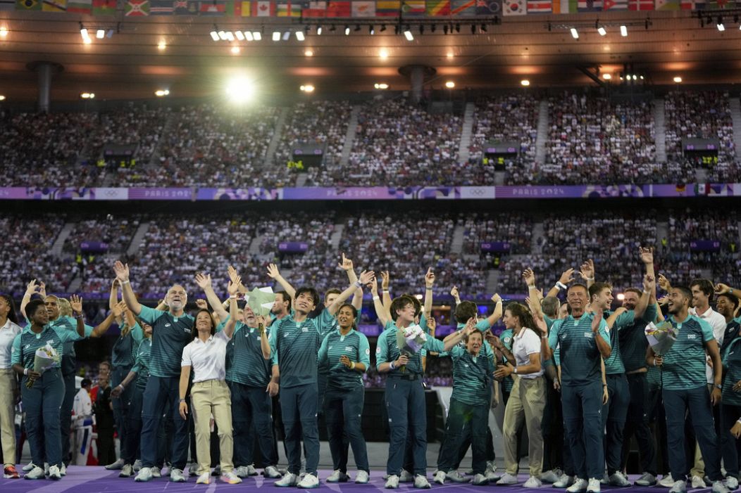 Des bénévoles saluent la cérémonie de clôture des Jeux olympiques d'été de 2024 au Stade de France, le dimanche 11 août 2024, à Saint-Denis, en France.