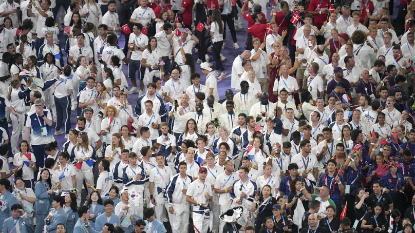 Participantes reúnem-se durante a cerimónia de encerramento dos Jogos Olímpicos de verão de 2024 no Stade de France, domingo, 11 de agosto de 2024, em Saint-Denis, França