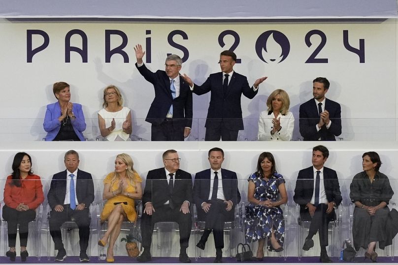 French President Emmanuel Macron, top, third right, and IOC President Thomas Bach wave during the 2024 Summer Olympics closing ceremony