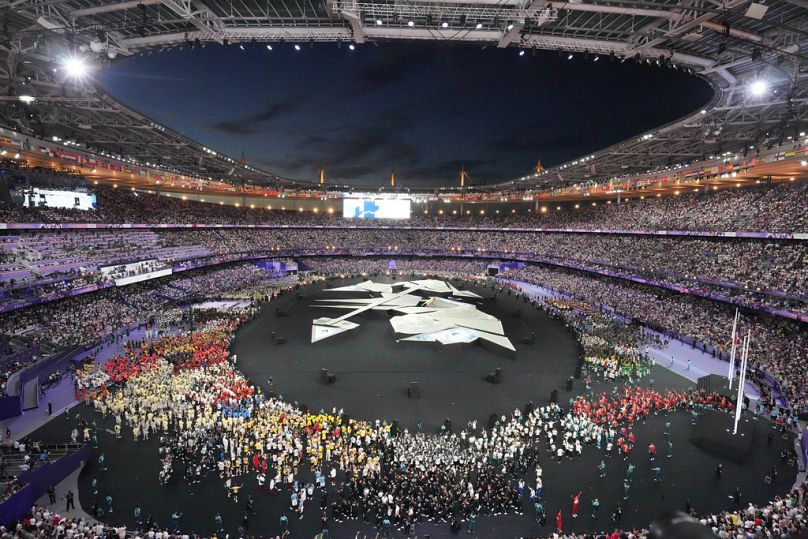 Atletas reúnem-se durante a cerimónia de encerramento dos Jogos Olímpicos de verão de 2024 no Stade de France, domingo, 11 de agosto de 2024, em Saint-Denis, França.