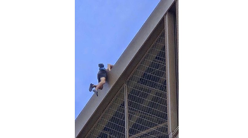 Hombre escalando la Torre Eiffel el día de la clausura de los Juegos Olímpicos