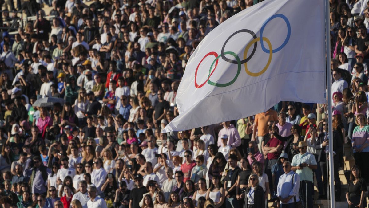 Olimpiyat bayrağı, 26 Nisan 2024 Cuma günü Atina'da, 1896 yılında ilk modern oyunların düzenlendiği Panathenaic stadyumunda Olimpiyat ateşinin devir teslim töreni sırasında dalgalanıyor