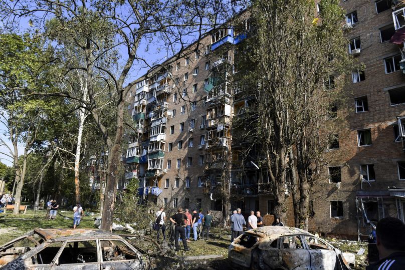 Persone si riuniscono davanti a un edificio danneggiato dai bombardamenti ucraini a Kursk, Russia, 11 agosto 2024