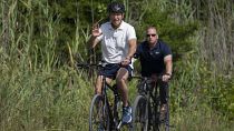 President Joe Biden, followed by a Secret Service agent, rides his bike at Gordons Pond in Rehoboth Beach, Delaware.